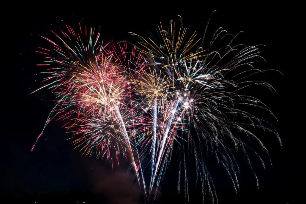 Fireworks explode in the sky. Photo by Elisha Terada on Unsplash