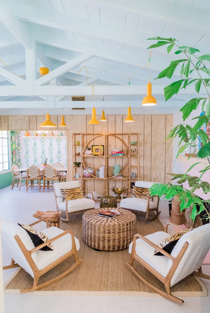 The lobby at Les Cactus Palm Springs with chairs around a wicker table and green plants