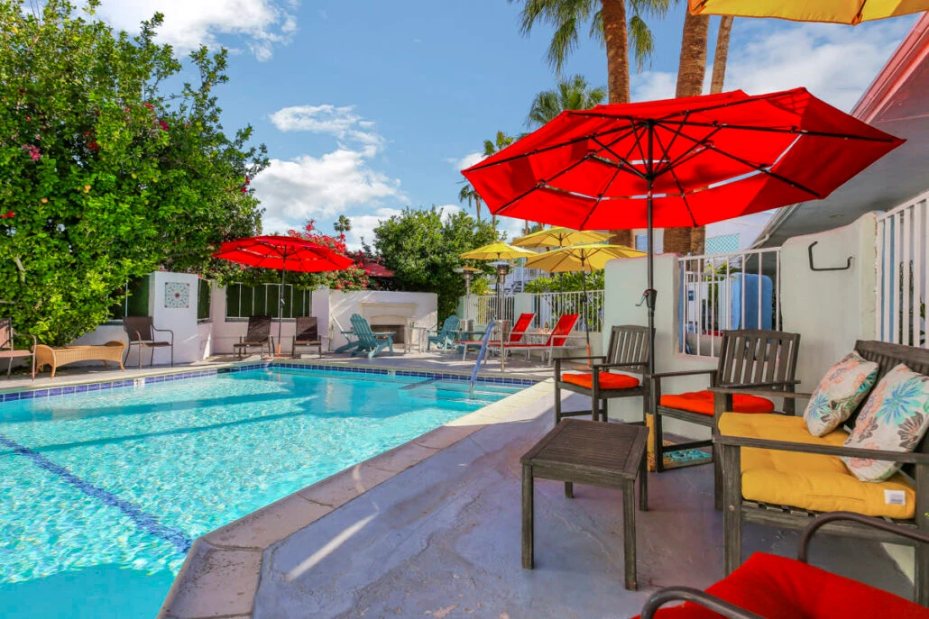 The pool at Inn at Palm Springs surrounded by umbrellas and chairs