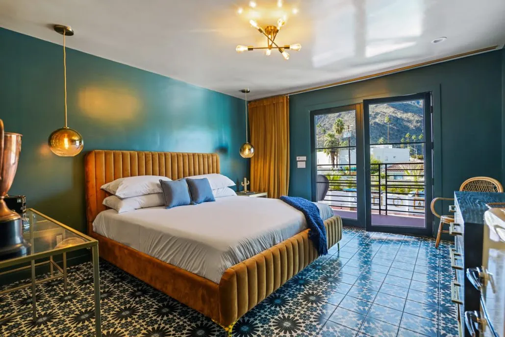 A bedroom at The Stardust Hotel Palm Springs with a blue painted wall and tile floor