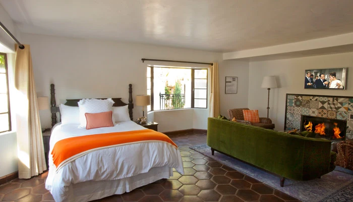A bed with a white bedspread next to a green couch at Ingleside Estate