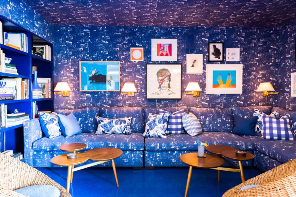 Art on a blue wallpapered wall at Holiday House Palm Springs