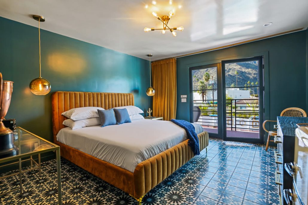 A bedroom at The Stardust Hotel Palm Springs with a blue painted wall and tile floor