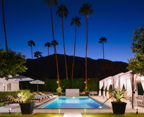 Night falls on the Hotel El Cid in Palm Springs, but the lights are still on in the pool area